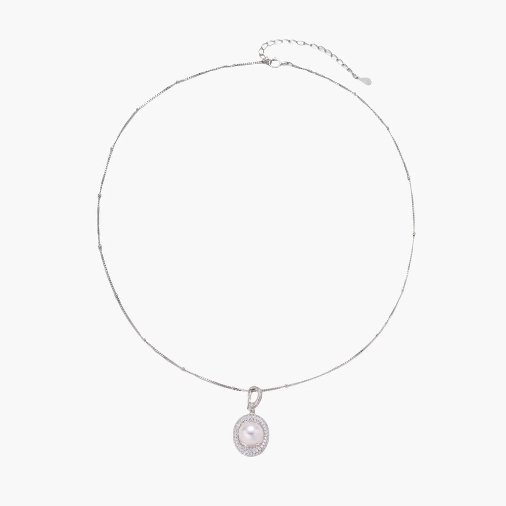 Oval sterling silver pendant with crystal halo surrounding a white freshwater pearl on delicate chain