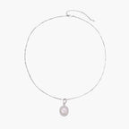 Oval sterling silver pendant with crystal halo surrounding a white freshwater pearl on delicate chain