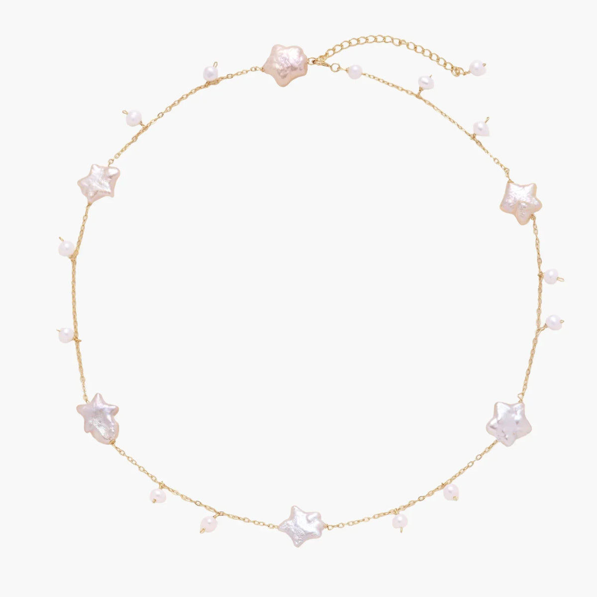 Gold vermeil chain with iridescent star-shaped baroque pearls and small round freshwater pearl drops on cream background.