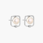Rhodium-plated silver stud earrings with cushion frame, centered freshwater pearl, and tiny crystal accent
