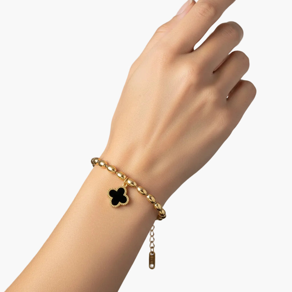 18K gold-plated oval bead chain bracelet with quatrefoil clover charm featuring mother of pearl inlay on cream background