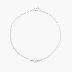 Dainty rhodium-plated silver chain necklace with centered 10mm freshwater pearl and crystal accents on cream background