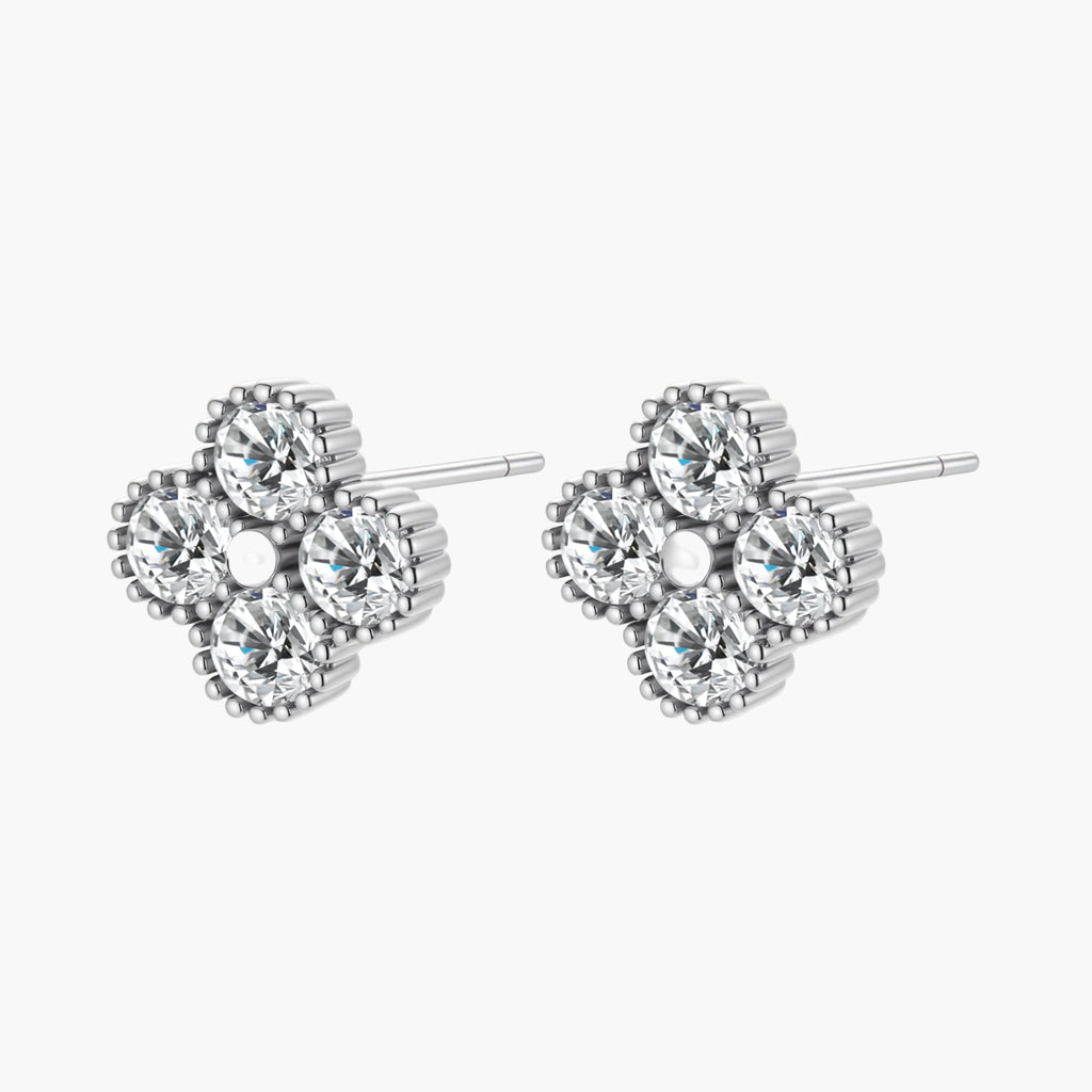 Dainty sterling silver quatrefoil stud earrings with four brilliant moissanite stones and center accent on white background.