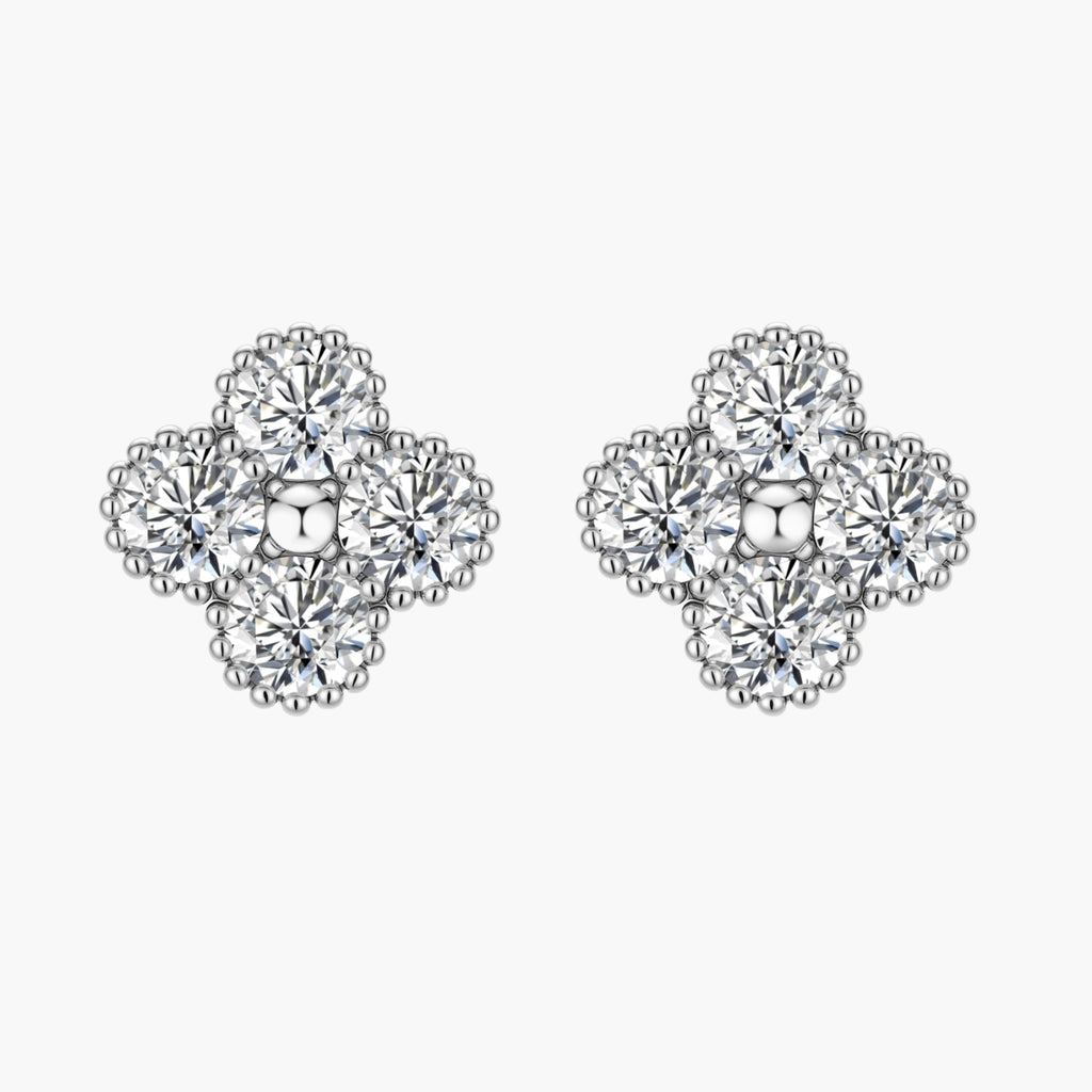 Dainty sterling silver quatrefoil stud earrings with four brilliant moissanite stones and center accent on white background.