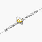 Sterling silver bracelet with yellow moissanite centerpiece in oval setting, crystal chain, and star charm on white background.